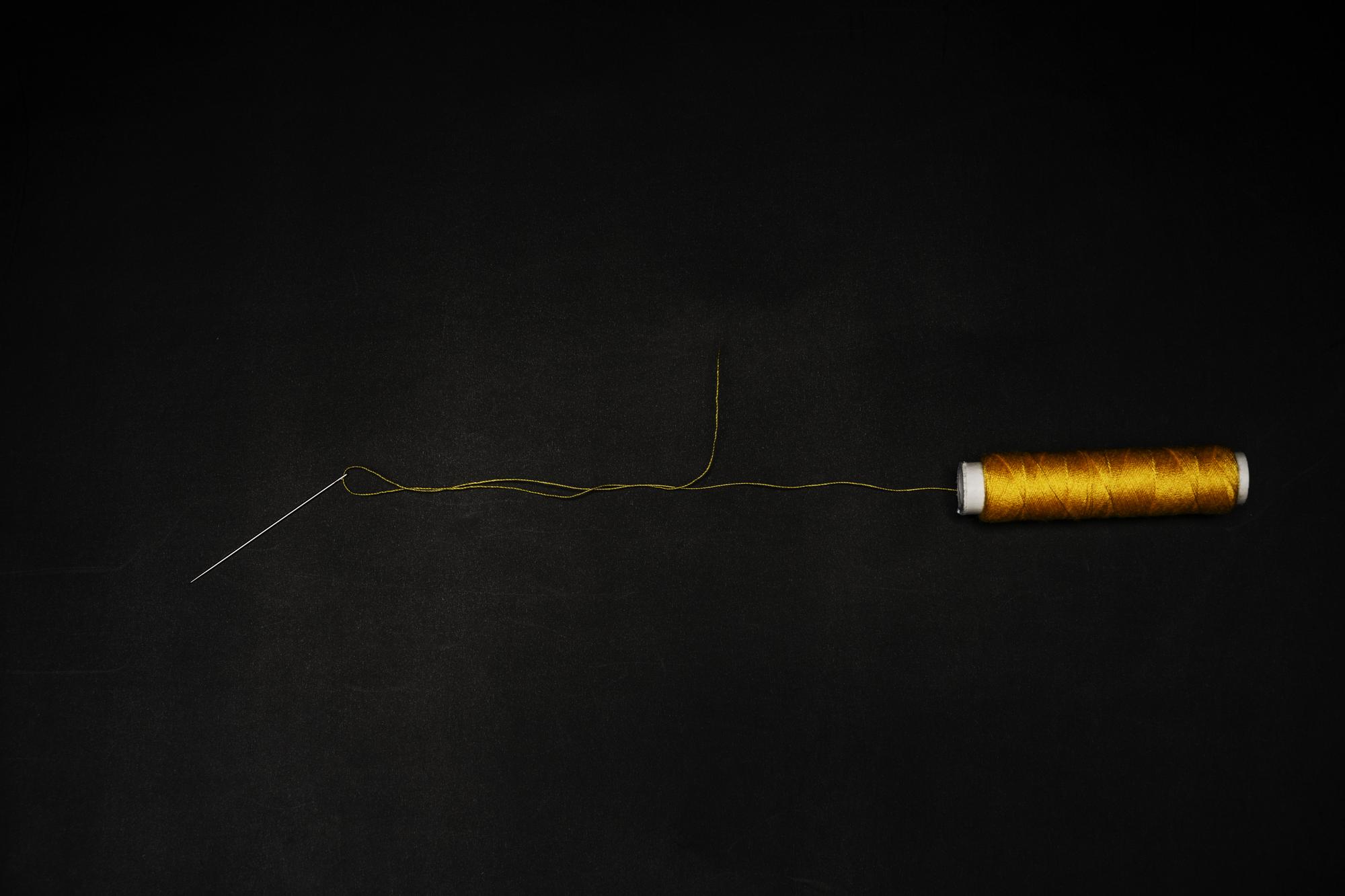 Small banner: stitches and thread on dark background